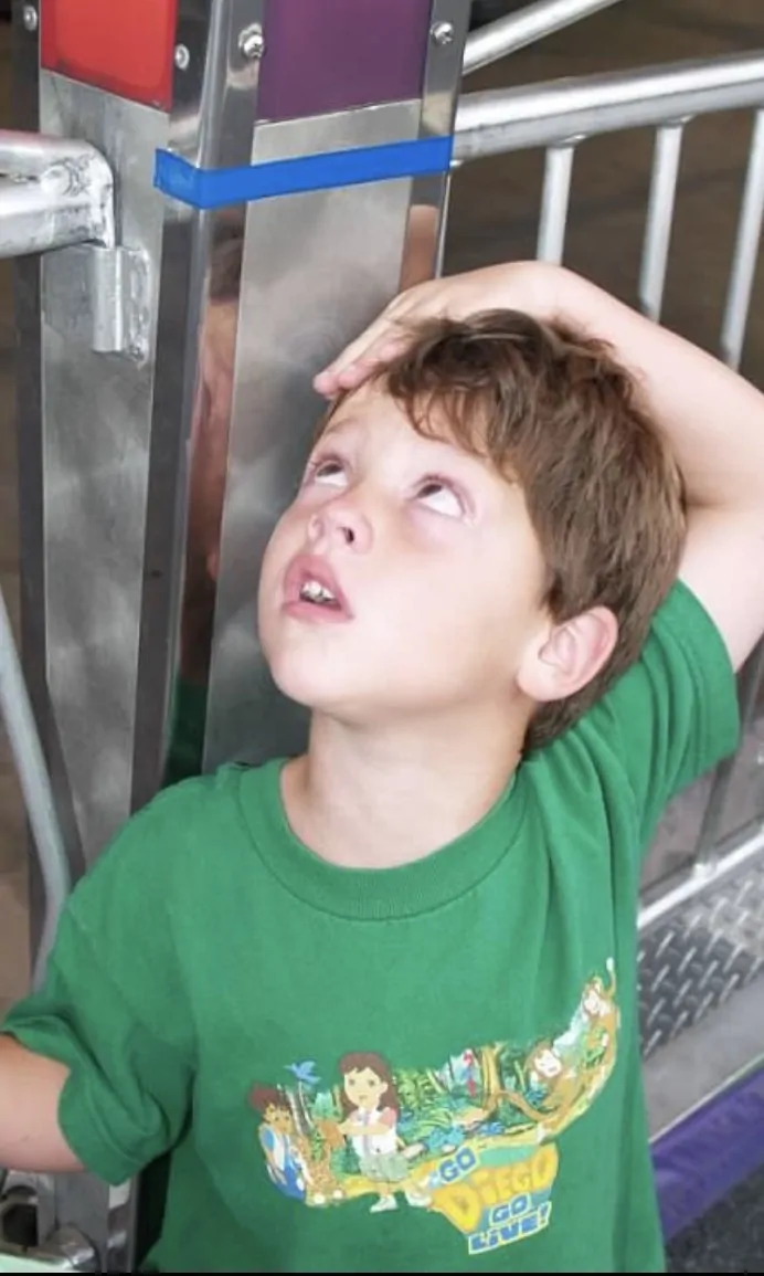 A young patient having his height measured against the growth chart