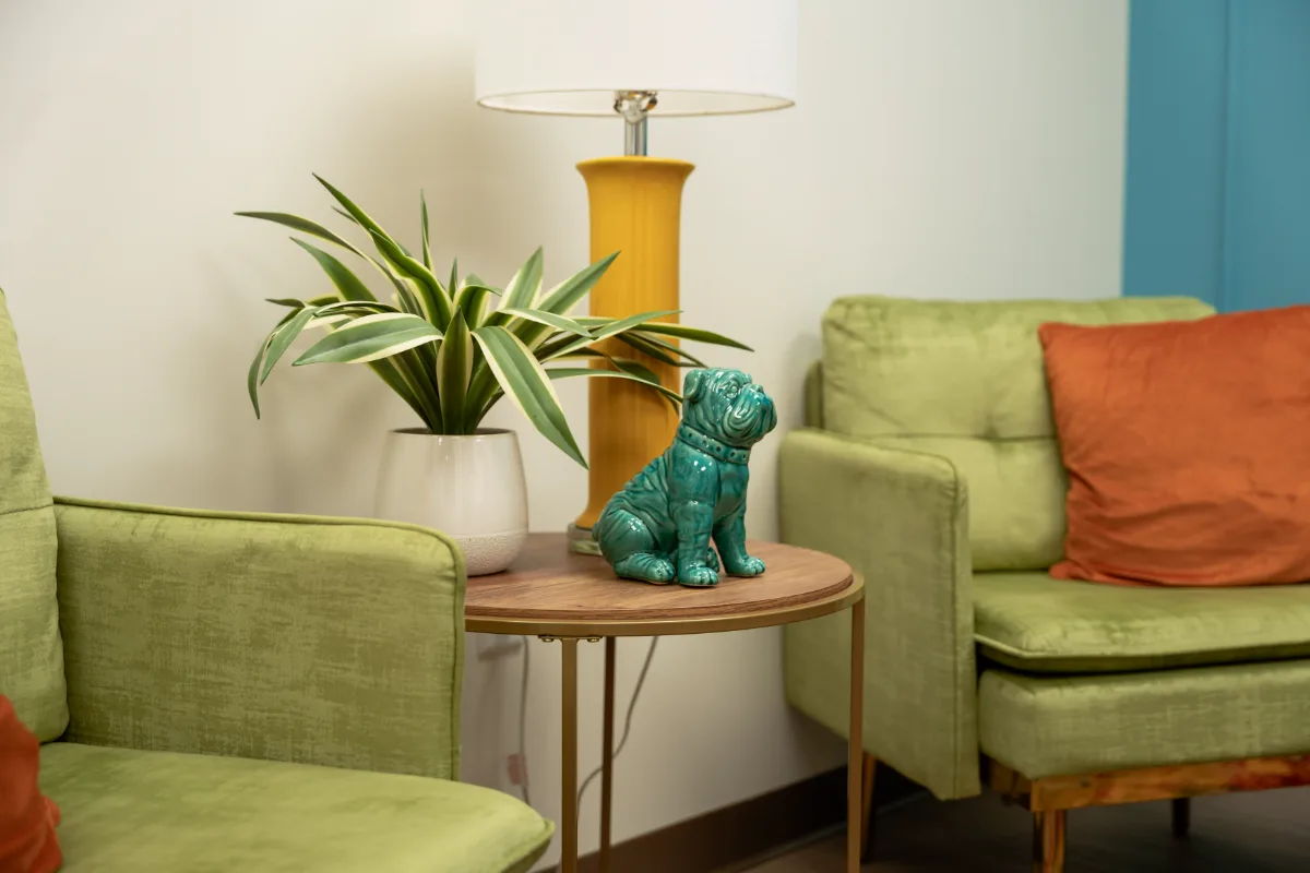 A corner of the waiting lounge with a yellow lamp and a teal bulldog figurine