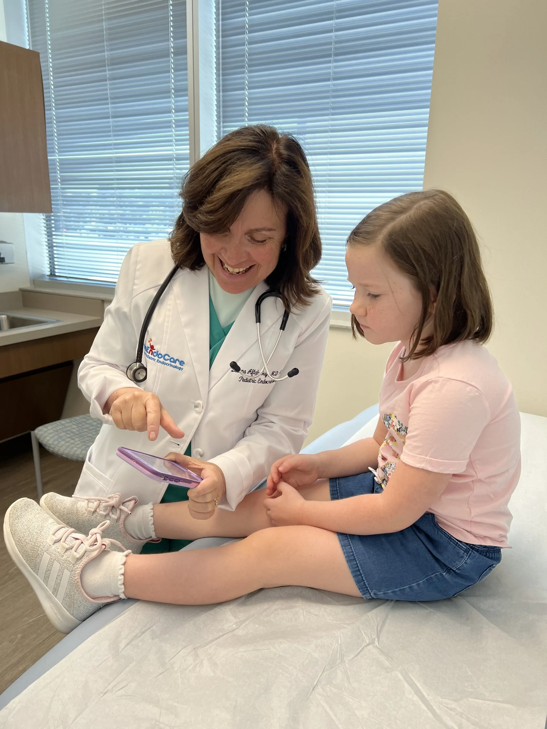 Dr. Aftab Guy examining a young patient on the exam table