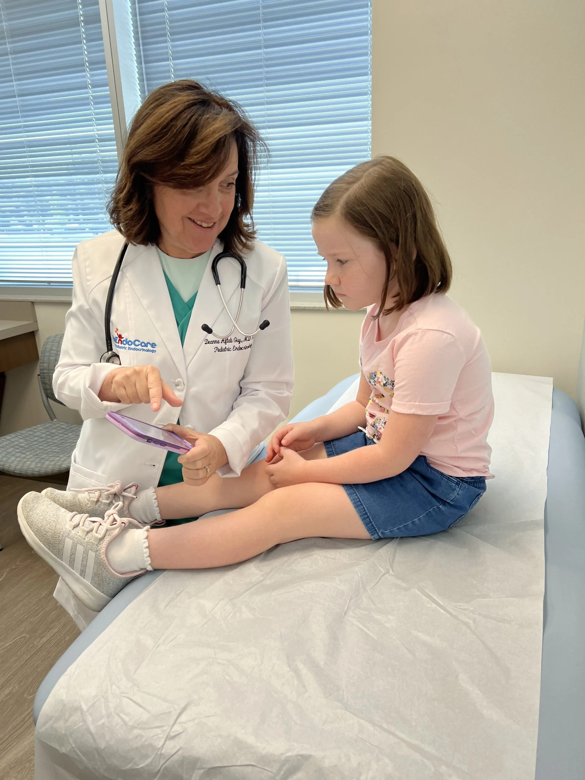 Dr. Aftab Guy examining a young patient on the exam table