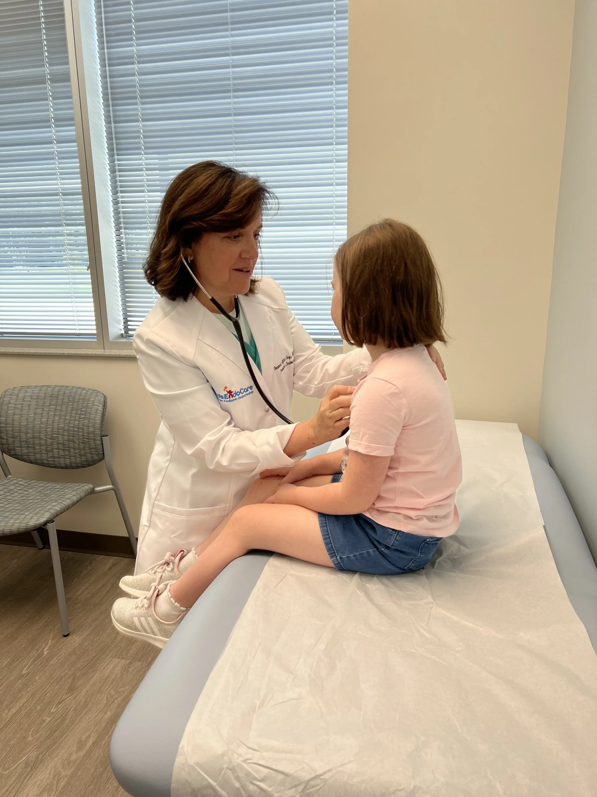 Dr. Aftab Guy examining a young patient on the exam table