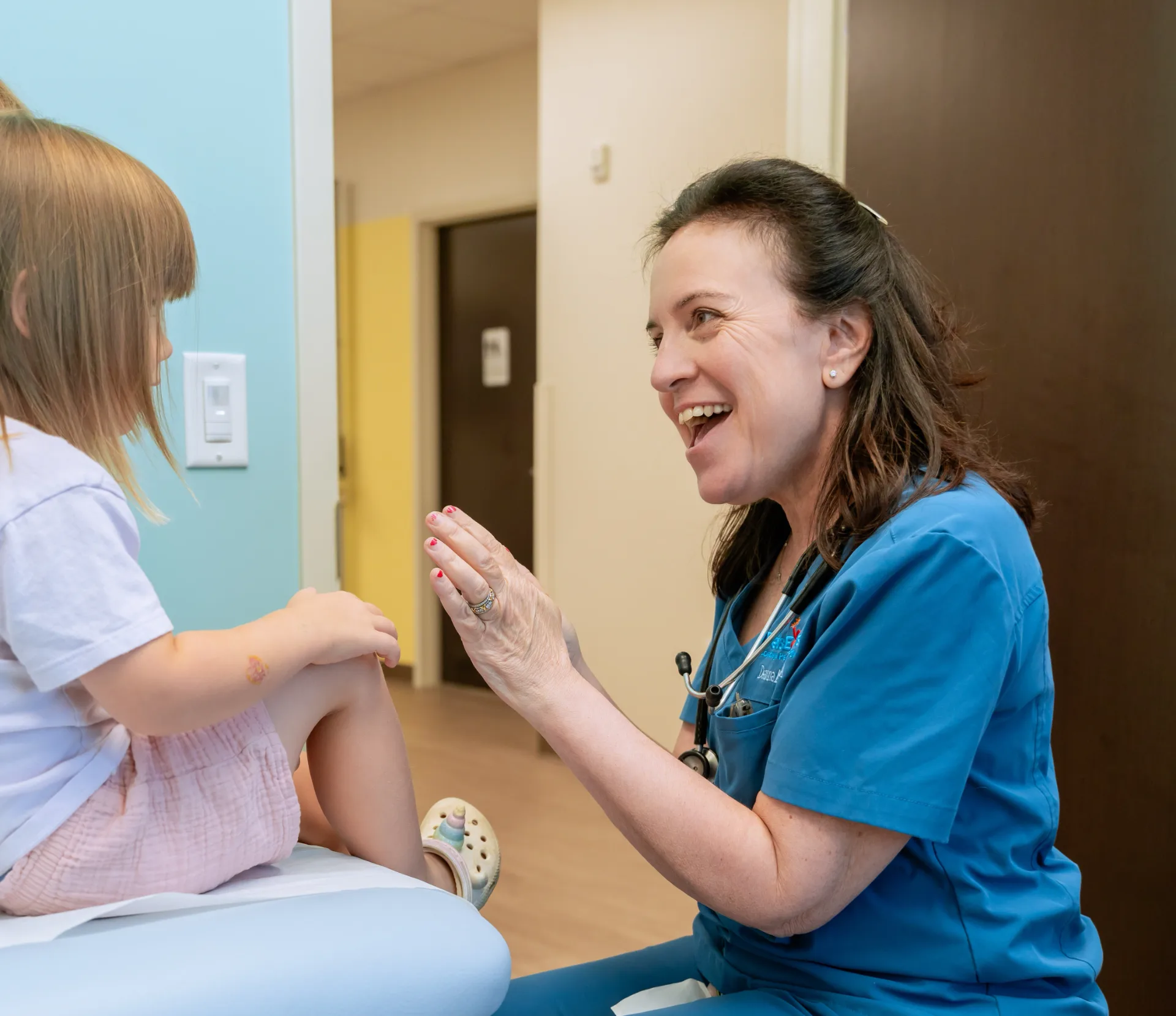 Dr. Aftab Guy laughing with a young patient during an appointment