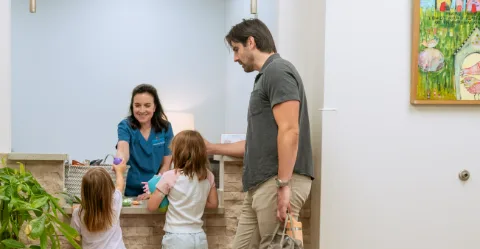 Dr. Aftab Guy with a young patient and her parent in the exam room